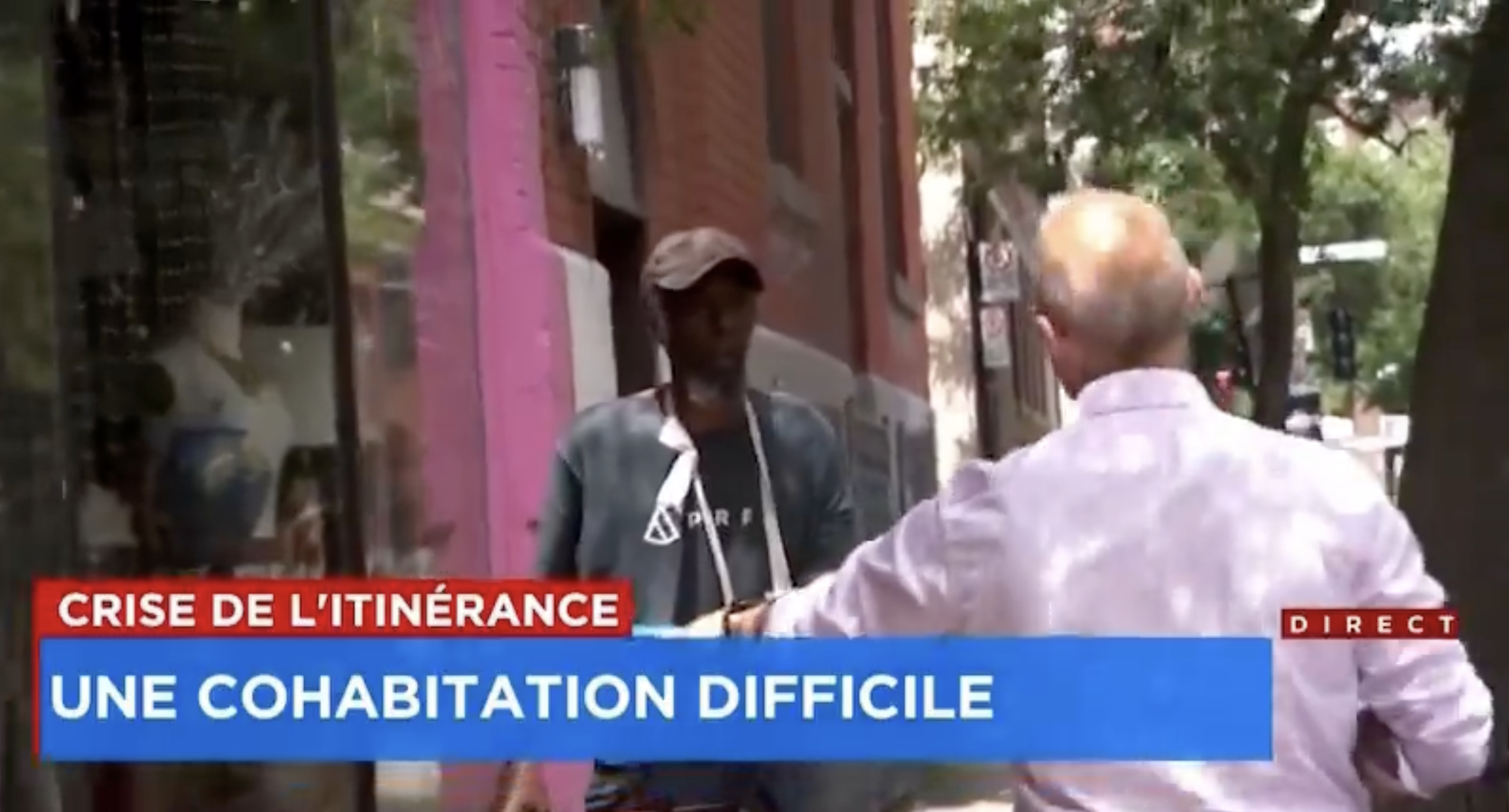 Yves Poirier questionne un itinérant devant un magasin de Montréal
